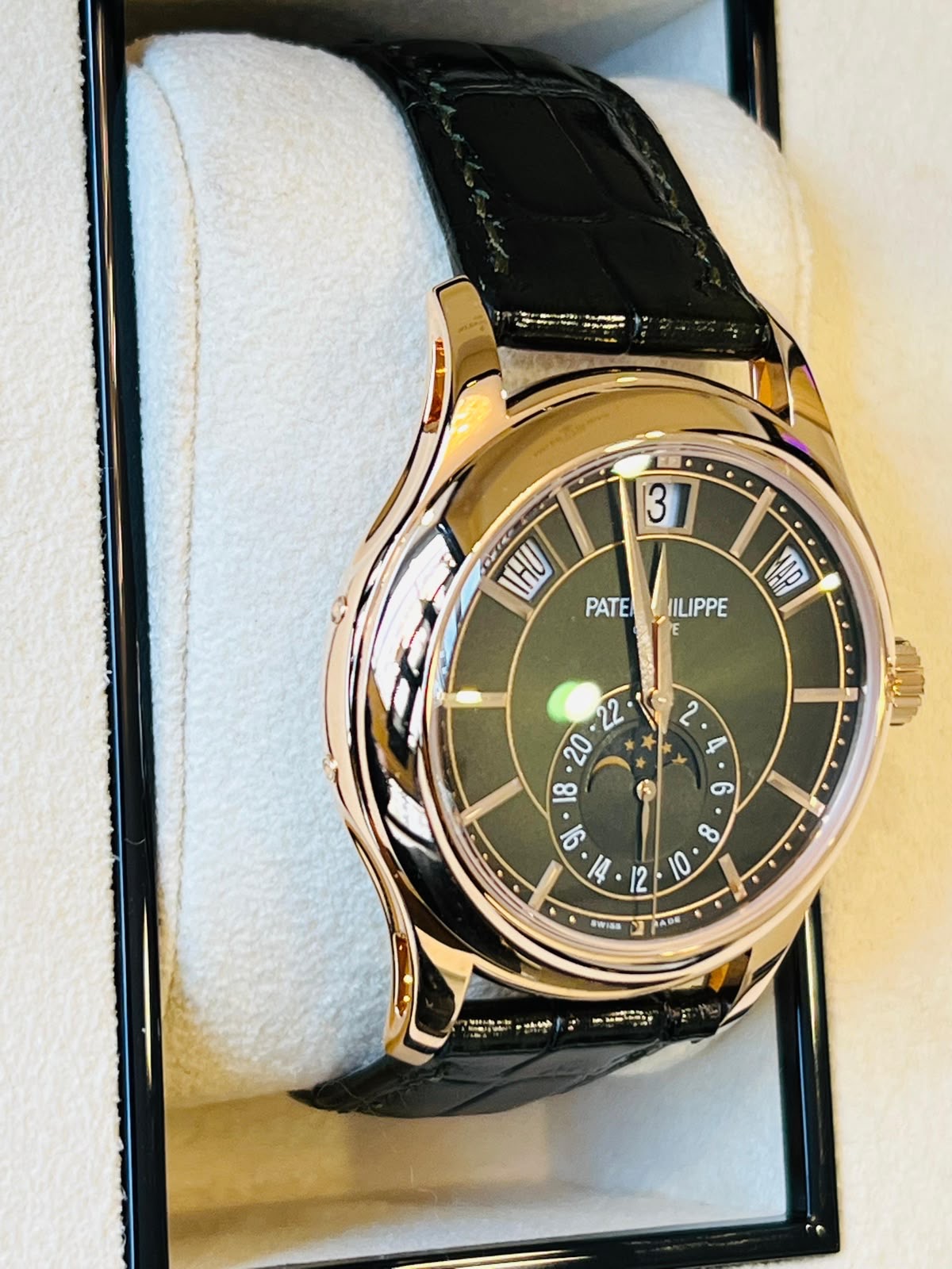 Goldene Uhr mit dunklem Zifferblatt und Lederarmband