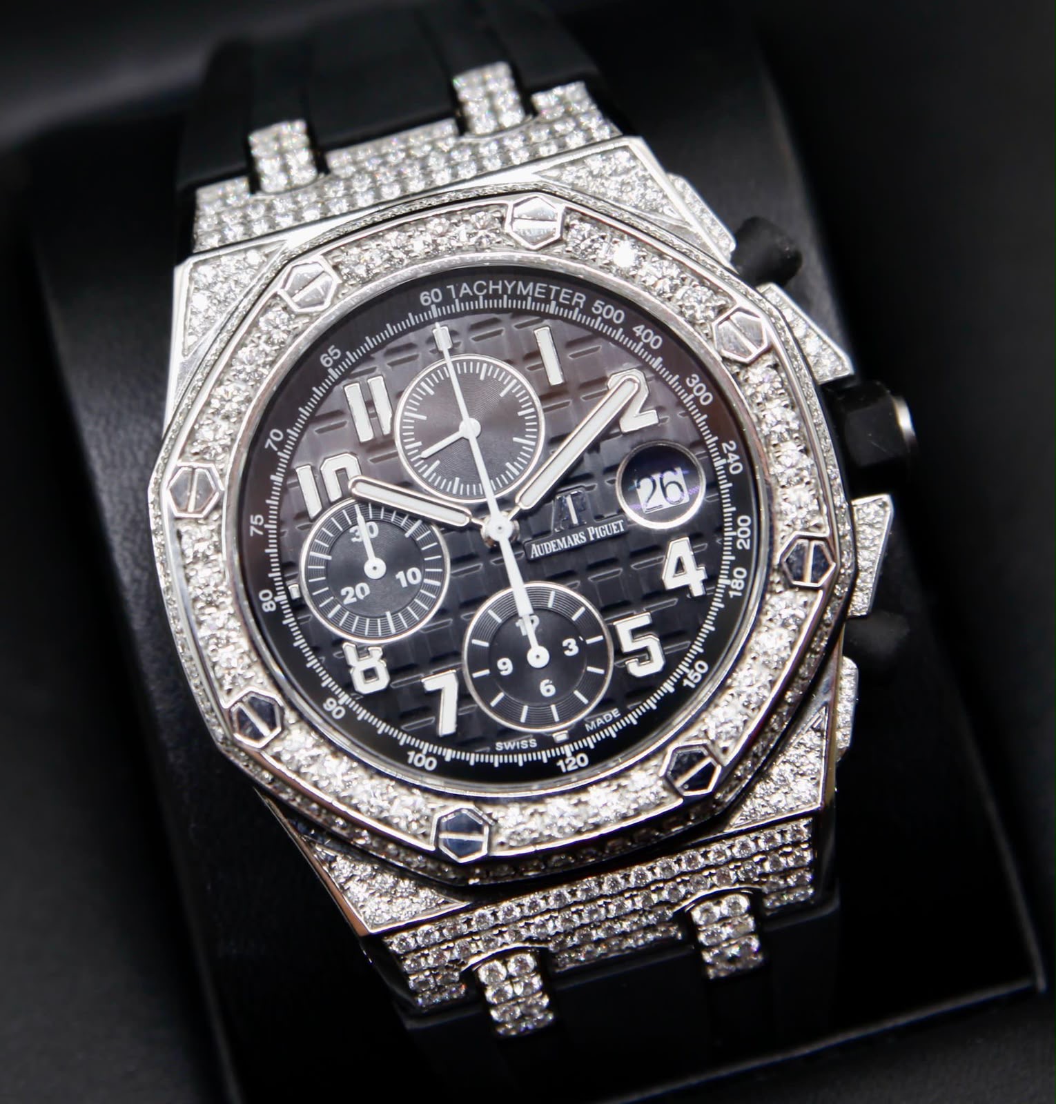Silberfarbener diamantbesetzter Chronograph mit dunklem Zifferblatt